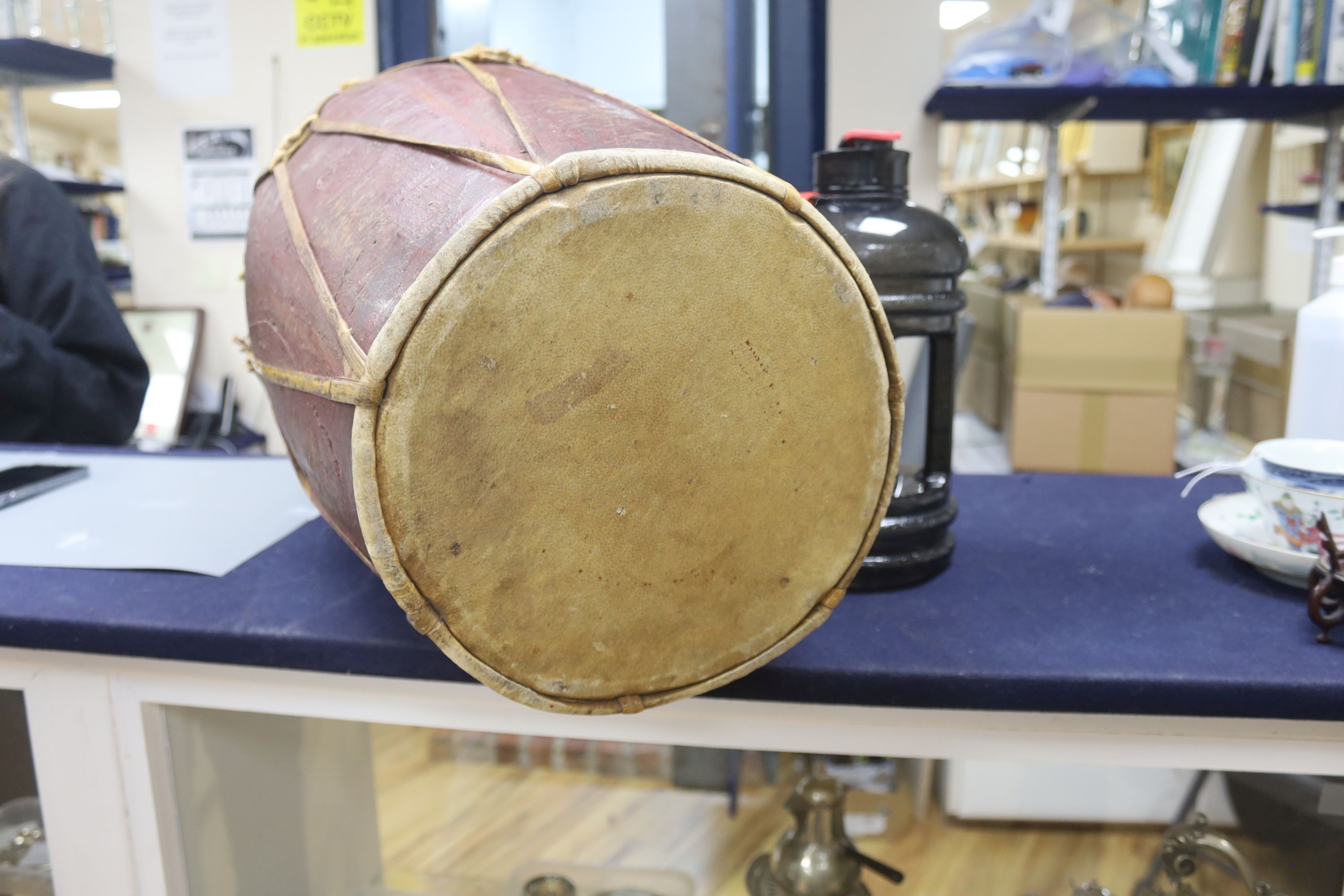 A tall tribal wooden drum, the vellum skins held by bamboo strapping and decorated in red and ochre - 62cm